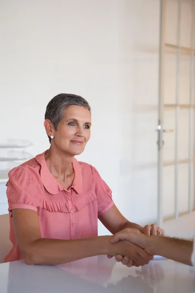 Business people shaking hands at desk — Stock Photo, Image