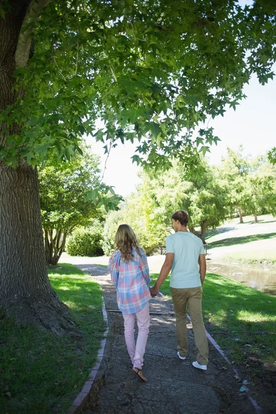 公園で手をつないで歩くカップル — ストック写真