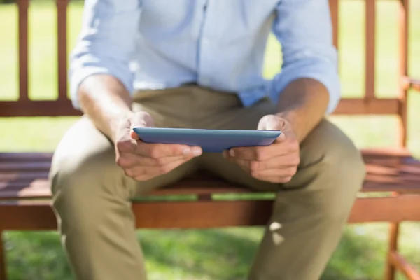 Homme sur banc de parc en utilisant la tablette — Photo