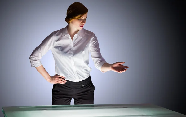Affärskvinna gestikulerande av ett skrivbord — Stockfoto