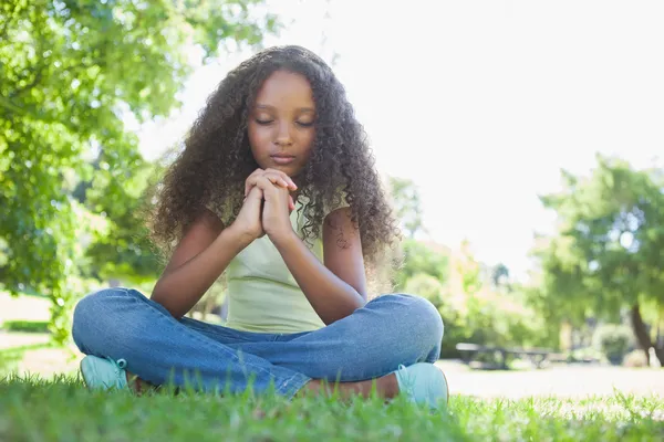 Girl praying in the park Royalty Free Stock Photos