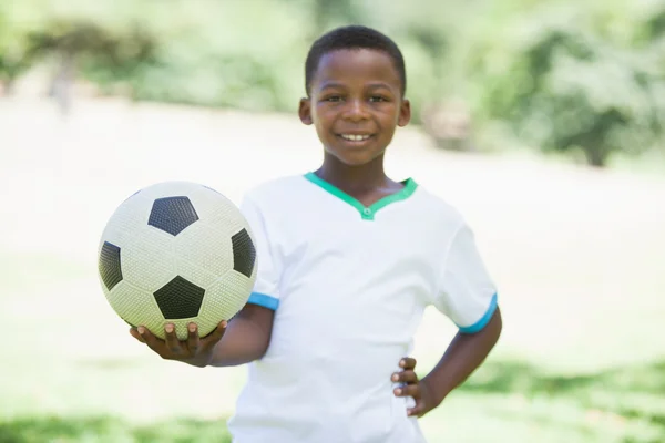 Niño sosteniendo el fútbol en el parque — Foto de Stock