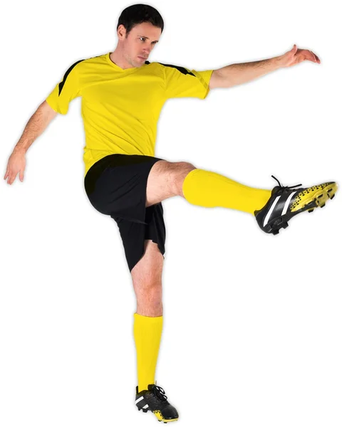Fotbalista v žluté kopal — Stock fotografie