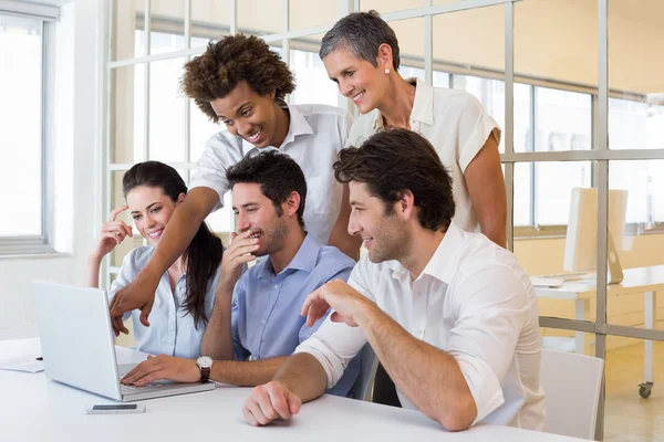 Werknemers lachen terwijl kijken naar laptop — Stockfoto