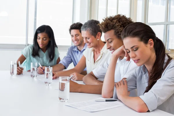 Business people writing in notebooks — Stock Photo, Image