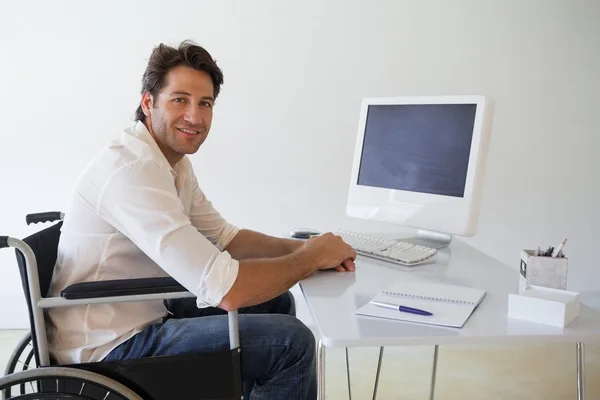 Бізнесмен в інвалідному візку працює за своїм столом — стокове фото