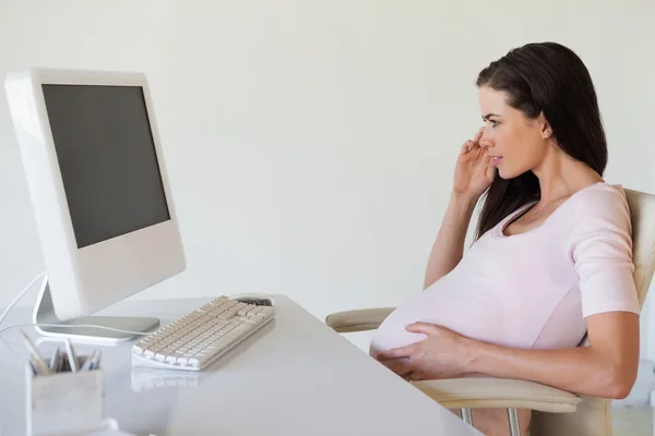 Gravid affärskvinna funderar på hennes skrivbord — Stockfoto