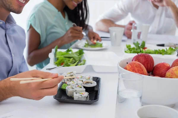Pessoas de negócios desfrutando de sushi e salada — Fotografia de Stock