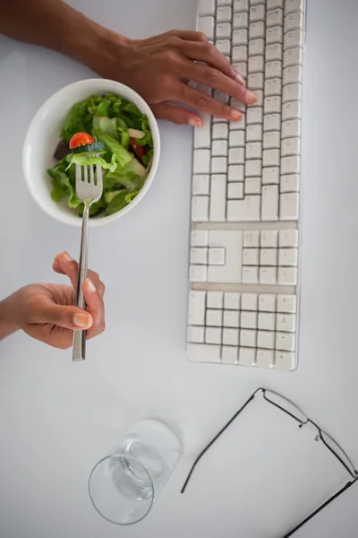 Femme d'affaires mangeant une salade à son bureau — Photo