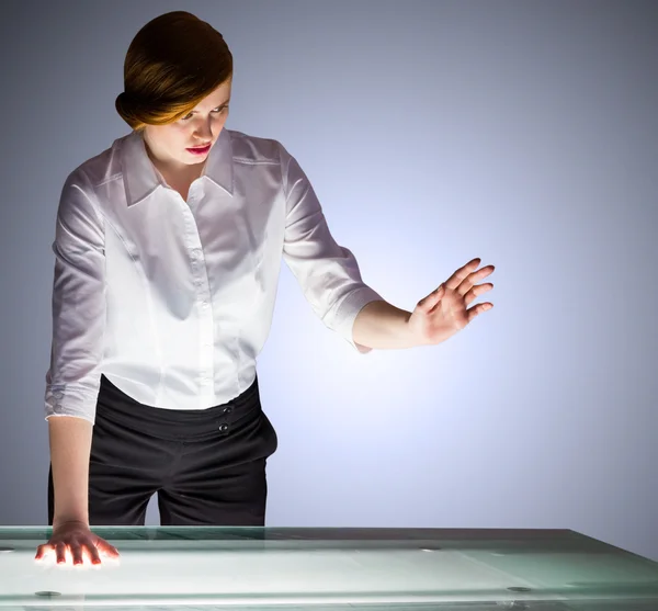 Businesswoman gesturing by a desk — Stock Photo, Image