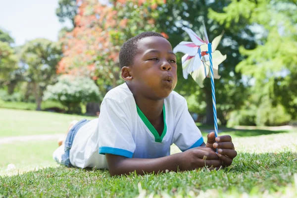 Menino soprando pinwheel no parque — Fotografia de Stock