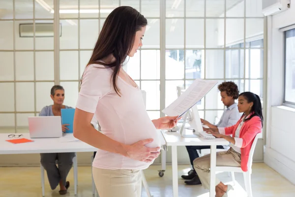 Lavoratrice incinta guarda il file — Foto Stock