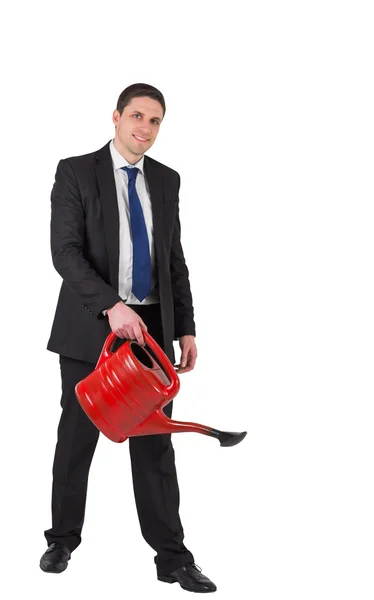 Businessman watering with red can — Stock Photo, Image