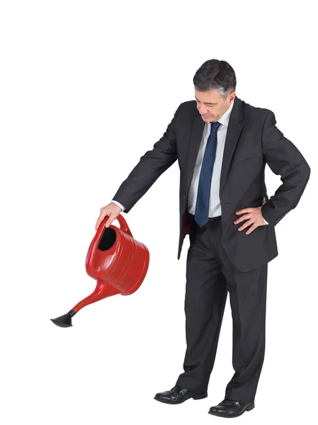 Businessman watering with red can — Stock Photo, Image