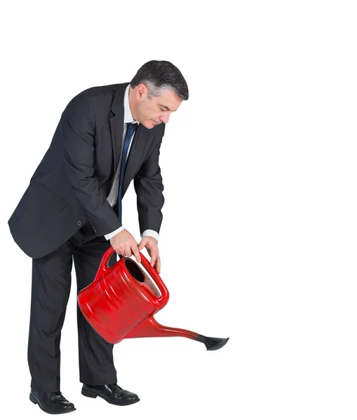 Businessman watering with red can — Stock Photo, Image