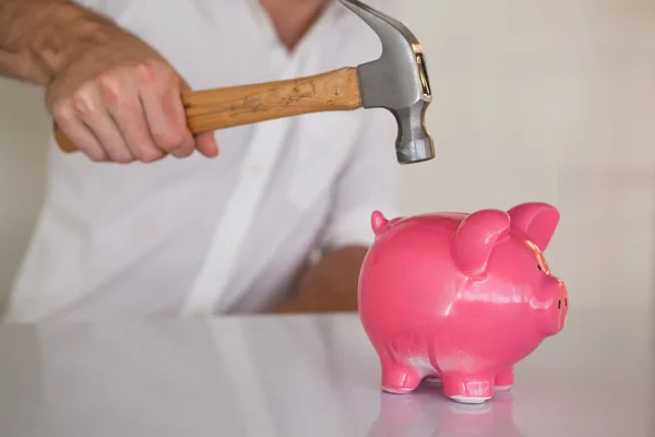 Empresário quebrando porquinho banco com martelo — Fotografia de Stock