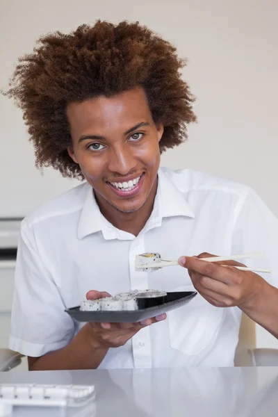 Empresário comendo sushi em sua mesa — Fotografia de Stock