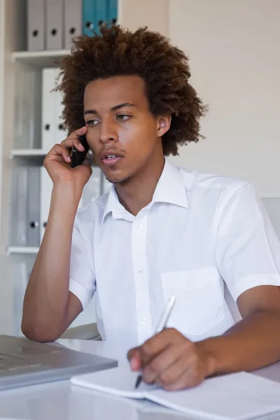 Geschäftsmann macht sich am Telefon Notizen — Stockfoto