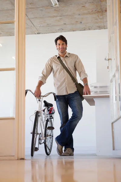Empresario de pie con su bicicleta — Foto de Stock