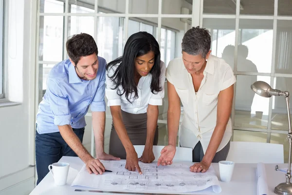 Drie architecten op zoek naar de blauwdrukken — Stockfoto