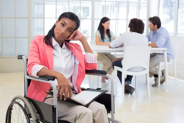 Woman with disability frowning with coworkers — Stock Photo, Image