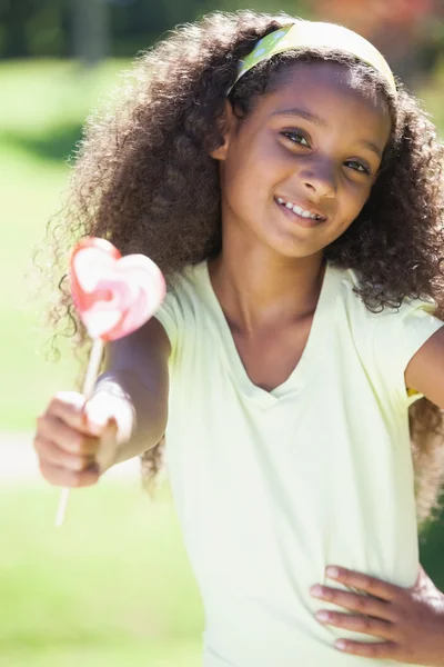 Girl holding a heart lollipop — Stock Photo, Image
