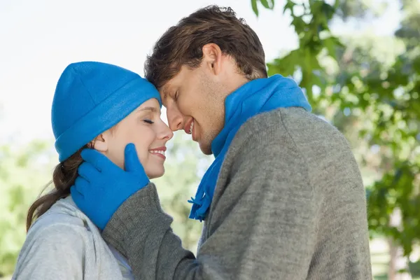 Couple in the park in hats and scarves — Stock Photo, Image