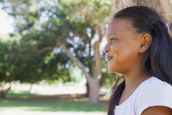 Little girl sitting by tree — Stock Photo, Image