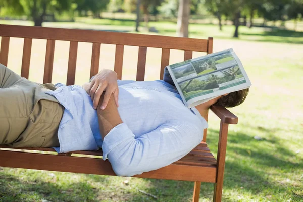 Homme dormant sur le banc du parc — Photo