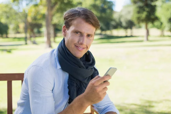 Man on bench sending a text — Stock Photo, Image