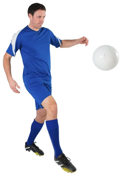 Jogador de futebol em azul chutando — Fotografia de Stock