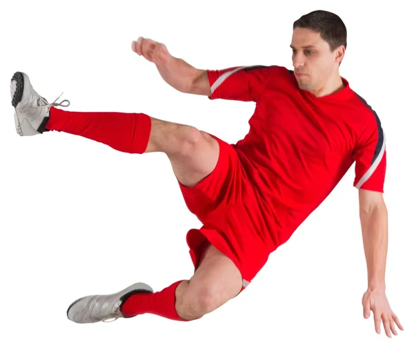 Jogador de futebol pulando e chutando — Fotografia de Stock