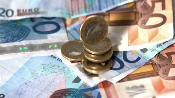 Monedas de euros cayendo sobre billetes — Vídeo de stock