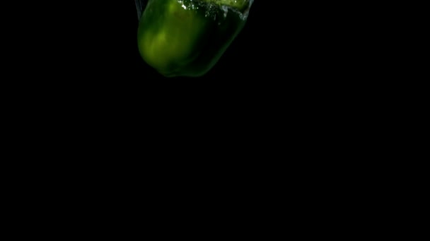 Зелений перець падає у воду — стокове відео