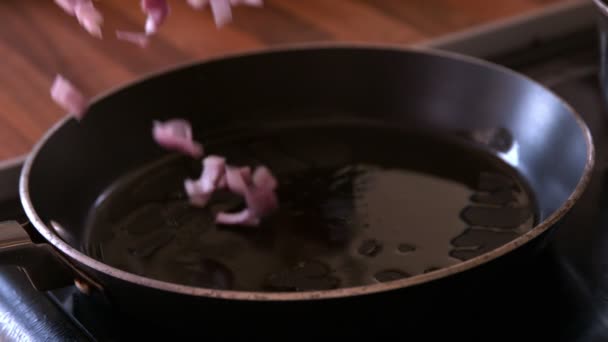 Onions dropped into frying pan — Stock Video