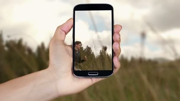 Mão mostrando clipes de aventura no smartphone — Vídeo de Stock