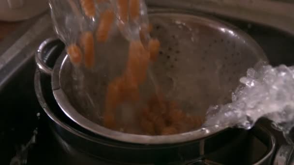 Pasta being poured into colander — Stock Video