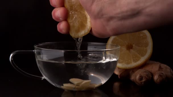 Hand squeezing lemon into cup — Stock Video