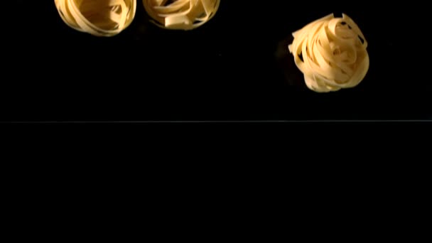 Taglietelle nests falling into water — Stock Video