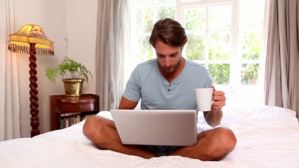 Людина за допомогою ноутбука тримає кухоль — стокове відео