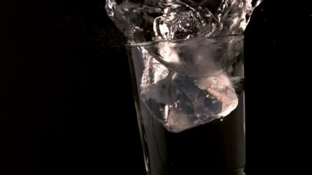 Cubitos de hielo cayendo en un vaso de agua — Vídeo de stock