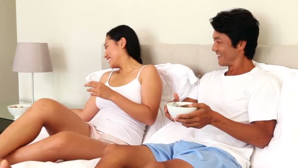 Casal comendo tigelas de cereais na cama — Vídeo de Stock