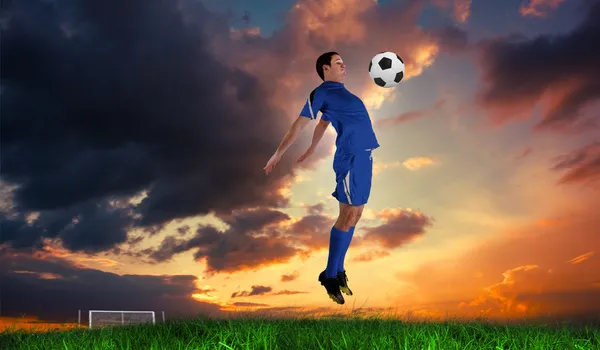 Jogador de futebol em salto azul — Fotografia de Stock