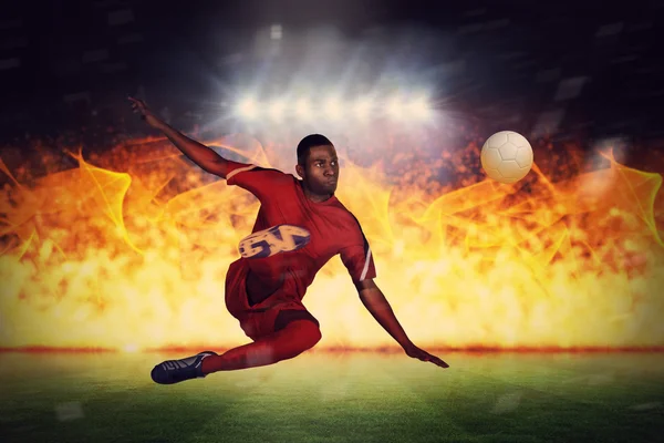 Jogador de futebol chutando contra campo de futebol — Fotografia de Stock