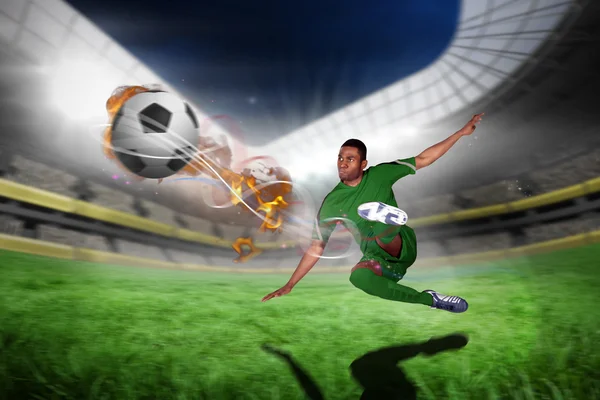 Football player in green kicking — Stock Photo, Image