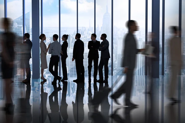 Compañeros de negocios hablando contra ventana grande — Foto de Stock