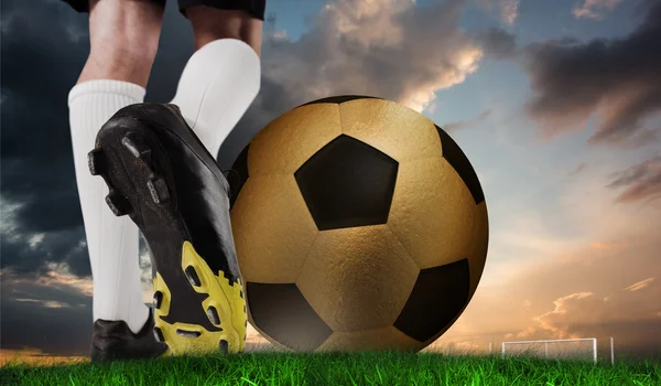 Football boot kicking huge gold ball — Stock Photo, Image