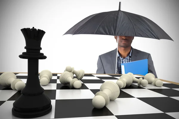 Businessman under umbrella with chessboard — Stock Photo, Image