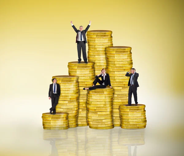 Business people on pile of coins — Stock Photo, Image
