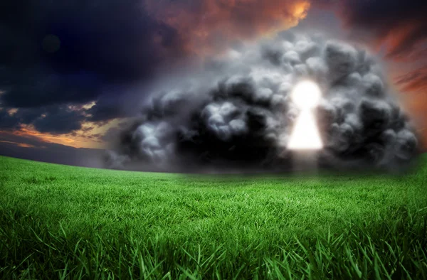 Belangrijkste gat in wolk tegen groen veld — Stockfoto